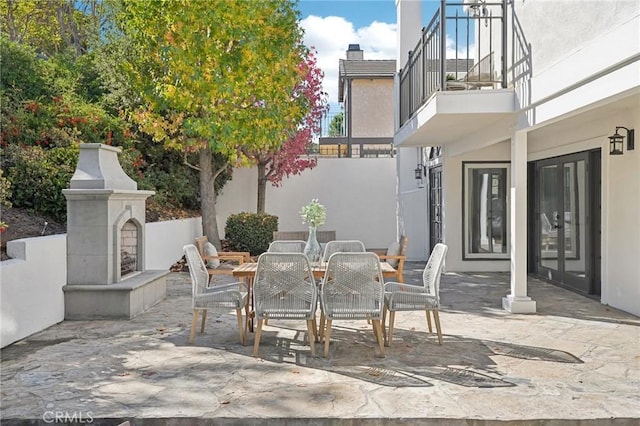 view of patio / terrace with a fireplace and a balcony