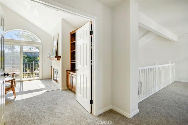 hall with light carpet and vaulted ceiling with beams