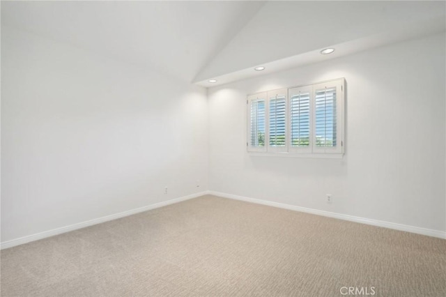 empty room with vaulted ceiling and carpet floors