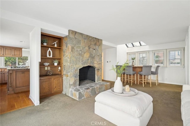 carpeted living room featuring a stone fireplace