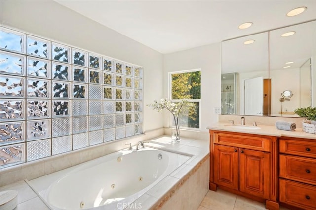 bathroom with vanity, tile patterned flooring, and tiled tub