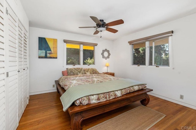 bedroom with a closet, wood-type flooring, and ceiling fan