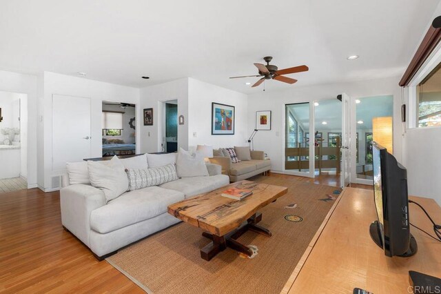 living room featuring ceiling fan and light hardwood / wood-style flooring