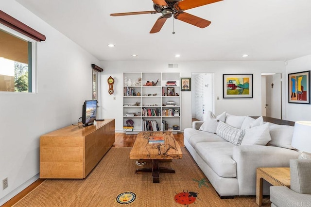 living room with ceiling fan and light hardwood / wood-style flooring