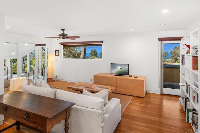 living room with ceiling fan and light hardwood / wood-style floors