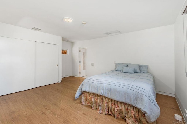 bedroom with light hardwood / wood-style flooring and a closet