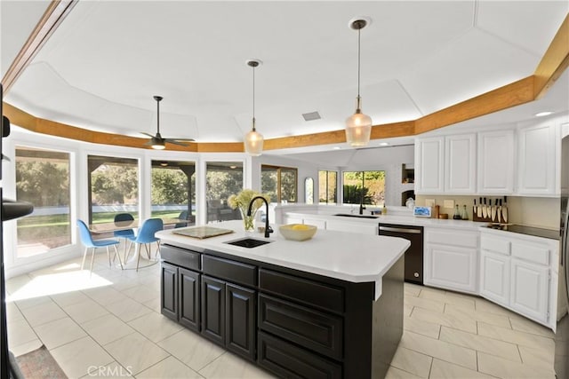 kitchen featuring ceiling fan, sink, stainless steel dishwasher, a center island with sink, and white cabinets