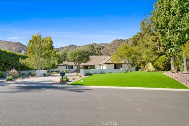 single story home featuring a mountain view and a front yard