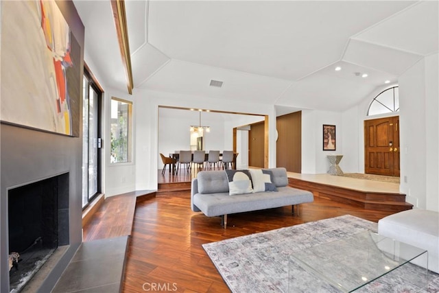 living room featuring vaulted ceiling and dark wood-type flooring