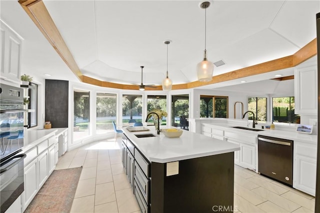 kitchen featuring dishwasher, a kitchen island with sink, a healthy amount of sunlight, and sink