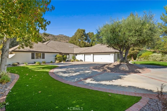 ranch-style home featuring a garage and a front lawn