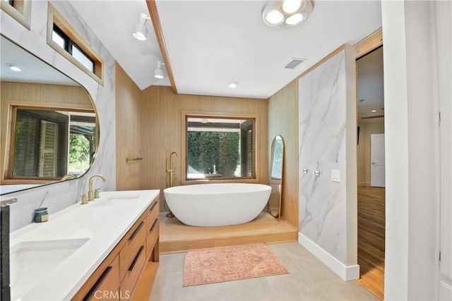 bathroom featuring vanity, a bath, and hardwood / wood-style flooring