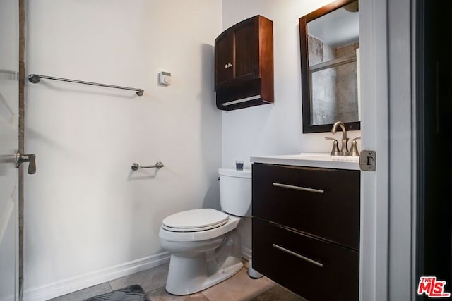 bathroom with toilet, vanity, tile patterned floors, and walk in shower