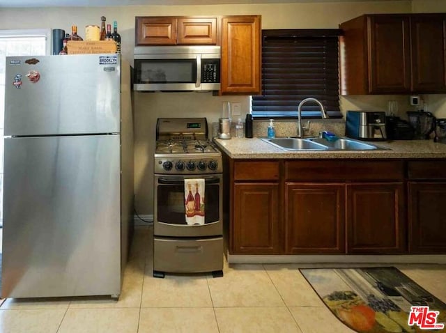 kitchen featuring appliances with stainless steel finishes, light tile patterned floors, and sink