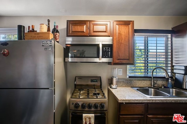 kitchen featuring appliances with stainless steel finishes, a healthy amount of sunlight, and sink