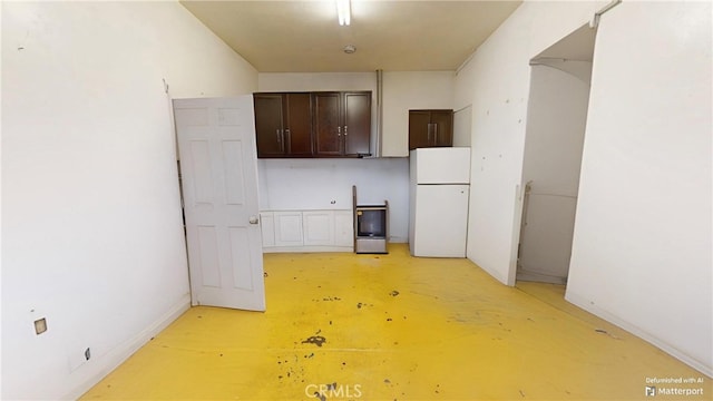 kitchen featuring dark brown cabinets and white refrigerator