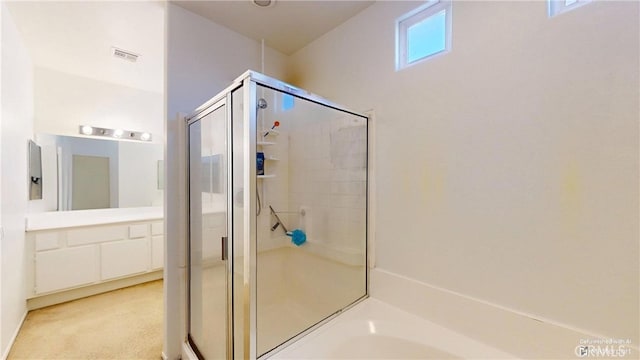 bathroom with vanity and shower with separate bathtub