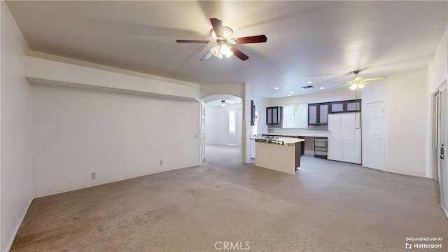 unfurnished living room with ceiling fan