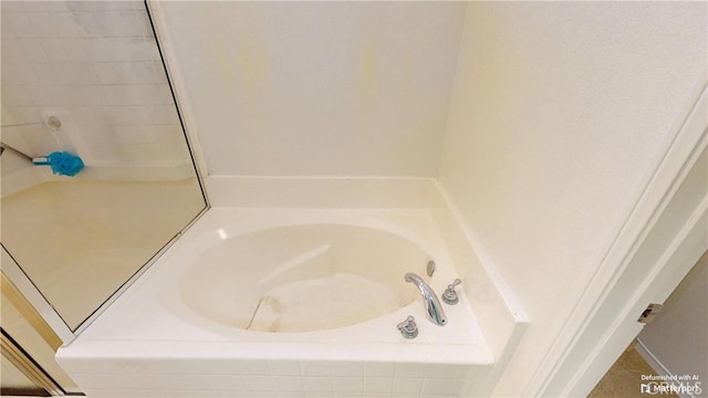 bathroom featuring tiled tub