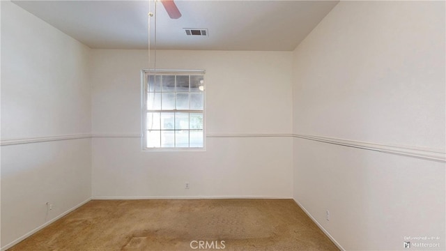 carpeted spare room with ceiling fan