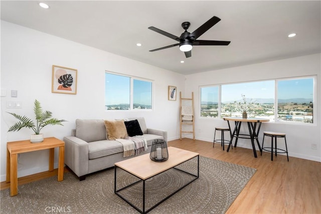 living area with a ceiling fan, recessed lighting, wood finished floors, and baseboards