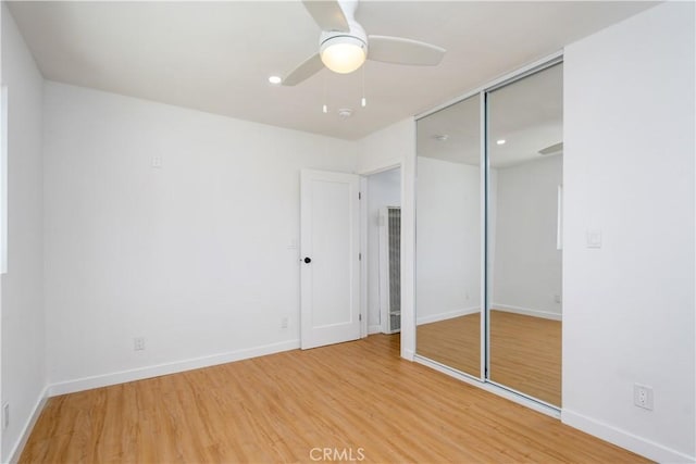 unfurnished bedroom featuring hardwood / wood-style flooring, ceiling fan, and a closet