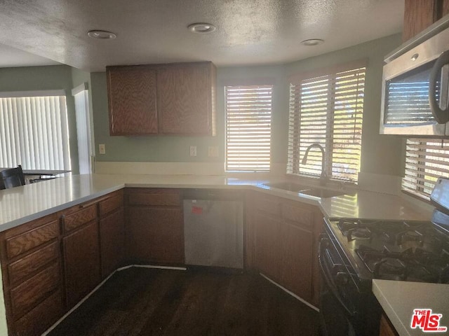 kitchen with range, a textured ceiling, sink, and dark hardwood / wood-style floors