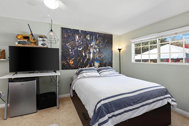 carpeted bedroom with stainless steel fridge and ceiling fan