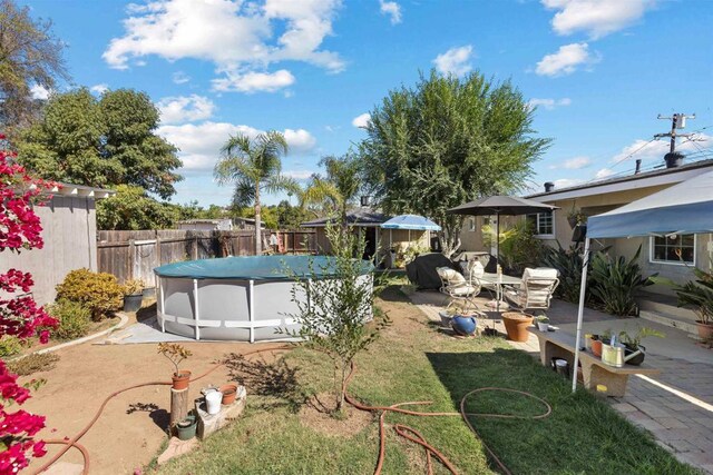 view of yard with a patio and a covered pool