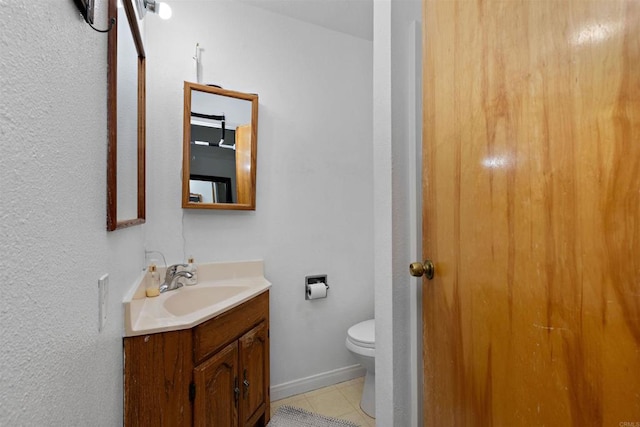 bathroom featuring tile patterned flooring, vanity, and toilet