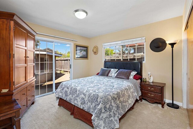 bedroom featuring access to exterior and light carpet