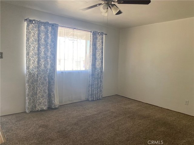 carpeted spare room with ceiling fan