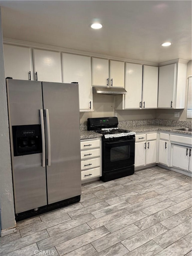 kitchen featuring light wood-type flooring, stainless steel fridge, black gas range, and white cabinets