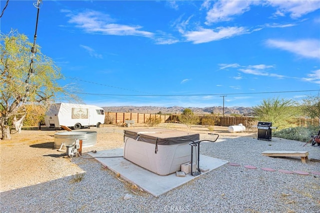 view of patio / terrace with a mountain view and a hot tub