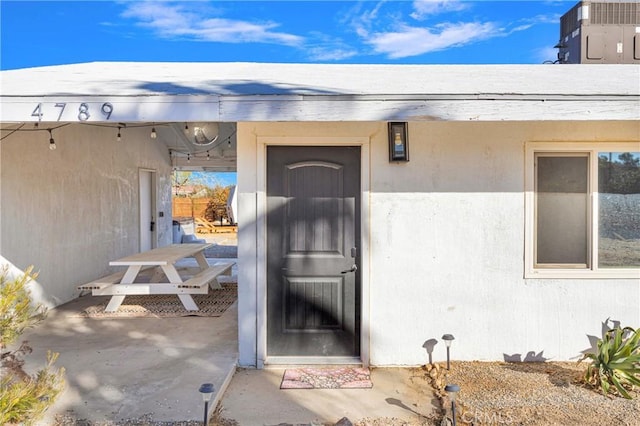 view of exterior entry with a patio