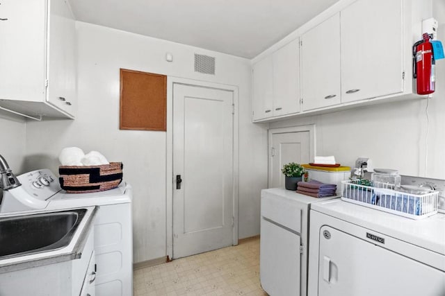 laundry area with cabinets, washer and clothes dryer, and sink