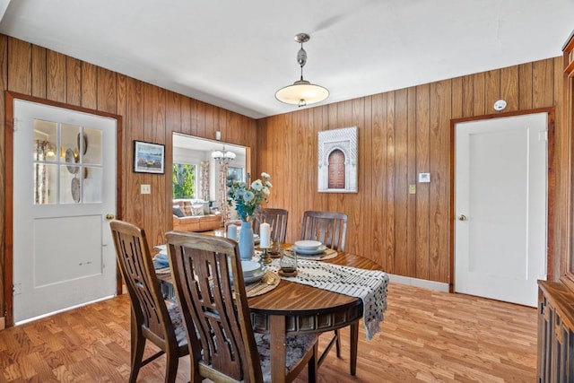 dining space with light hardwood / wood-style flooring and a notable chandelier