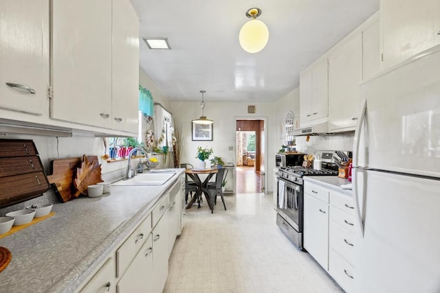 kitchen featuring decorative light fixtures, sink, white cabinets, gas range, and white refrigerator