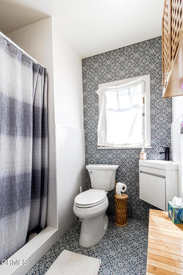 full bathroom featuring a shower with curtain, toilet, and wallpapered walls
