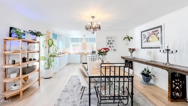 dining space with a chandelier and light wood-style floors