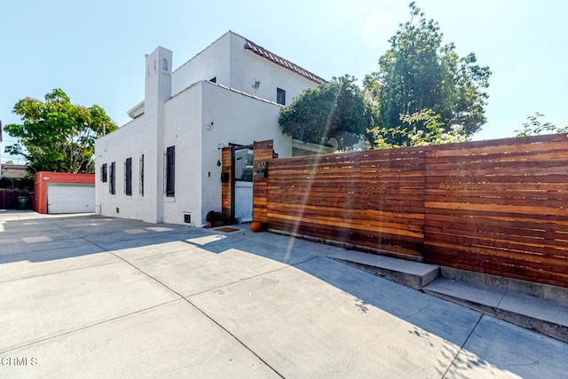 view of side of home with fence and stucco siding