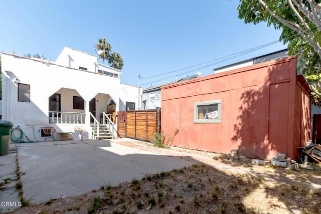 rear view of property with stucco siding and fence