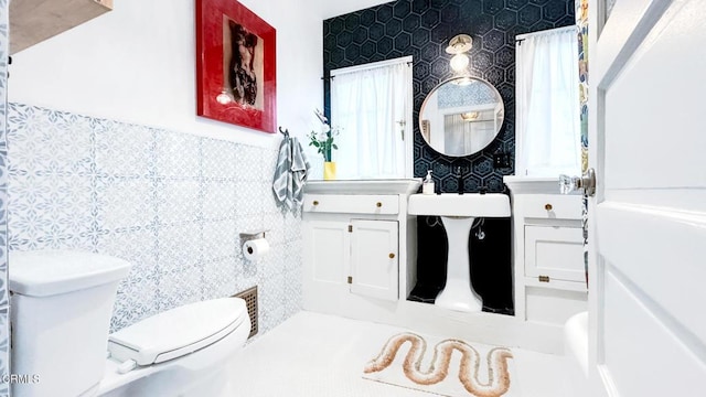 bathroom featuring tile walls and toilet