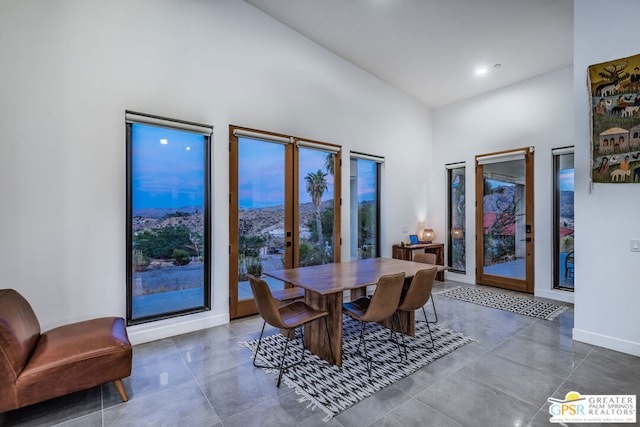 tiled dining space featuring a high ceiling