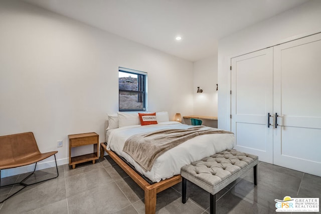 bedroom with tile patterned flooring and a closet