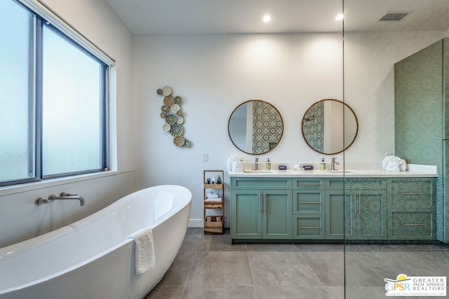 bathroom featuring tile patterned flooring, vanity, and a bath