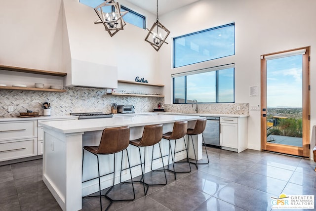 kitchen featuring a center island, hanging light fixtures, a breakfast bar area, white cabinets, and appliances with stainless steel finishes