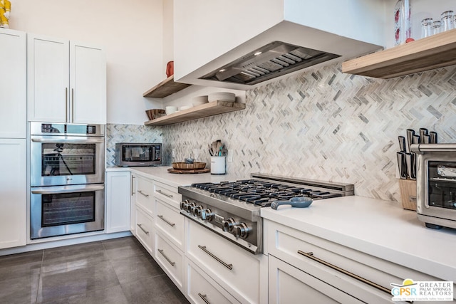 kitchen featuring exhaust hood, white cabinetry, stainless steel appliances, and decorative backsplash