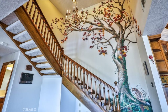 stairs with a notable chandelier