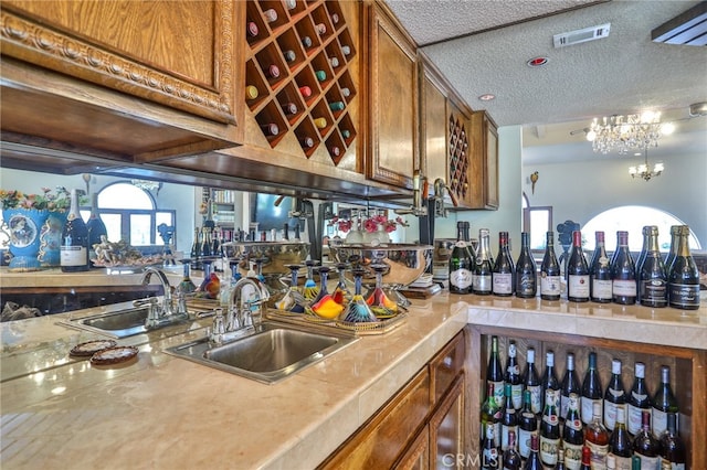 interior space with a notable chandelier, sink, and a textured ceiling